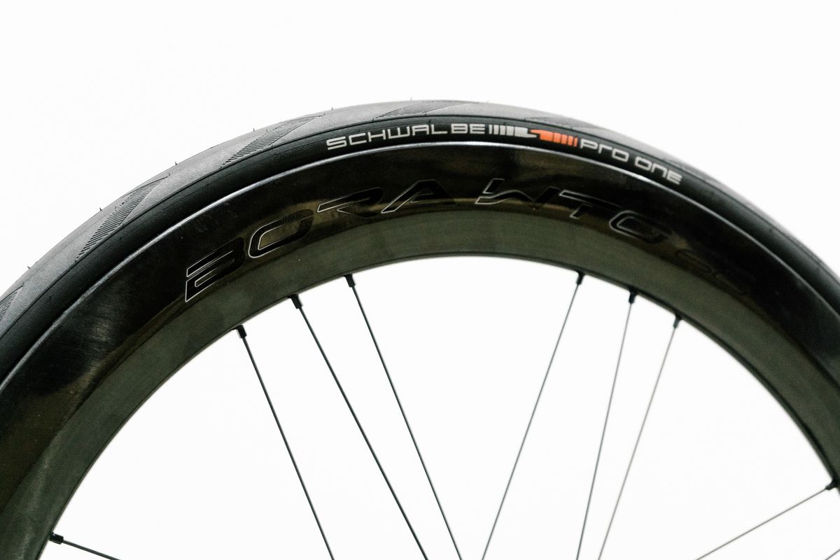 An aero road wheel stands against a white wall