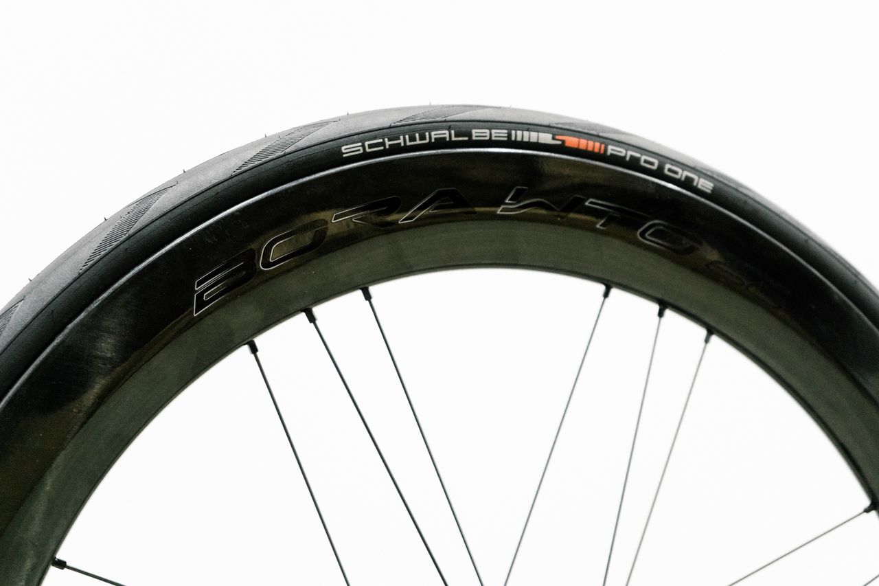An aero road wheel stands against a white wall