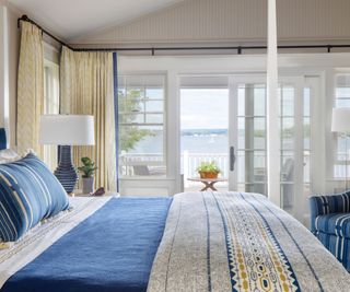 bedroom with terrace and lakeside view and blue bedding