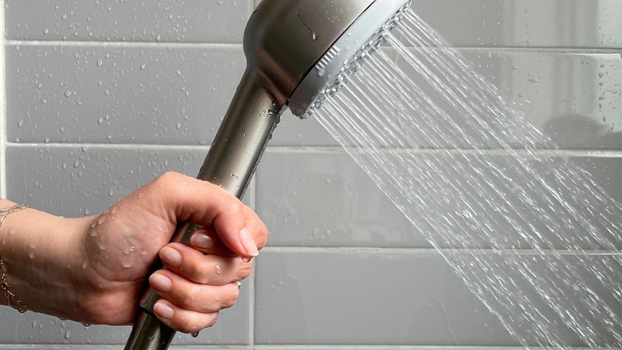 canopy showerhead held by a person in a shower