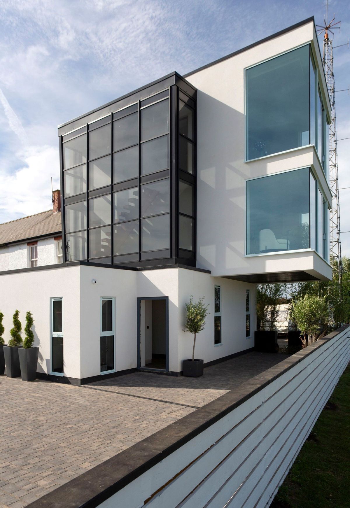 A white steel and glass box home on a coastal plot
