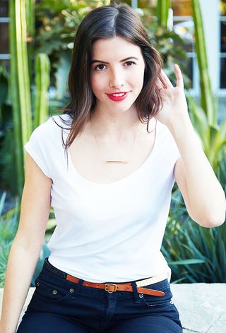 a close-up photo of an editor wearing a white t-shirt and jeans with a t-shirt bra