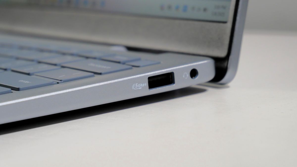 Dell 14 Plus open on a white desk, highlighting the ports on the right.