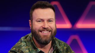 Taran Killam smiling on $100,000 Pyramid