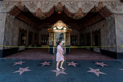 A woman walks in front of the El Capitan Theater in Hollywood.