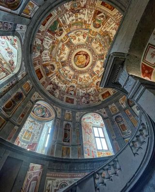View up to frescoed dome ceiling in Palazzo Delle Pietre hotel in Rome