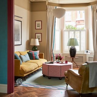 Living room with yellow sofa, painted architraves and blue walls