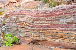 Banded iron formation. Scientists beleive increases in chromium in rock deposits is evidence of the great oxidation event.