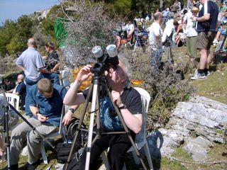 Skywatchers use telescopes with solar filters to observe the total solar eclipse of March 29, 2006, in Antalya, Turkey. Wearing solar viewing glasses will not protect your eyes when used with binoculars or telescopes — you must have an appropriate filter.