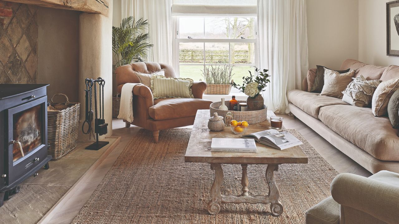 A neutral-coloured living room with a wood burning stove and a jute rug in front of it