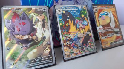 Three Pokemon Journey Together cards leaning against the Elite Trainer Box from the set