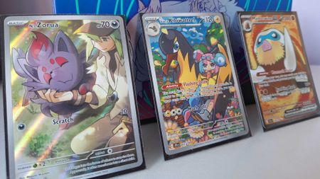Three Pokemon Journey Together cards leaning against the Elite Trainer Box from the set