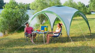 People sitting at camping table under gazebo