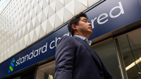 Standard Chartered bank branch with a person walking in front of it