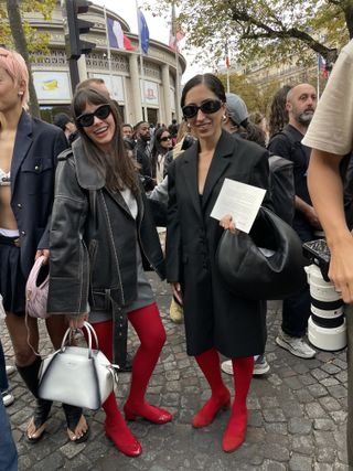 Kat Collings in Paris wearing a leather jacket and red tights with red shoes and a white Prada bag.