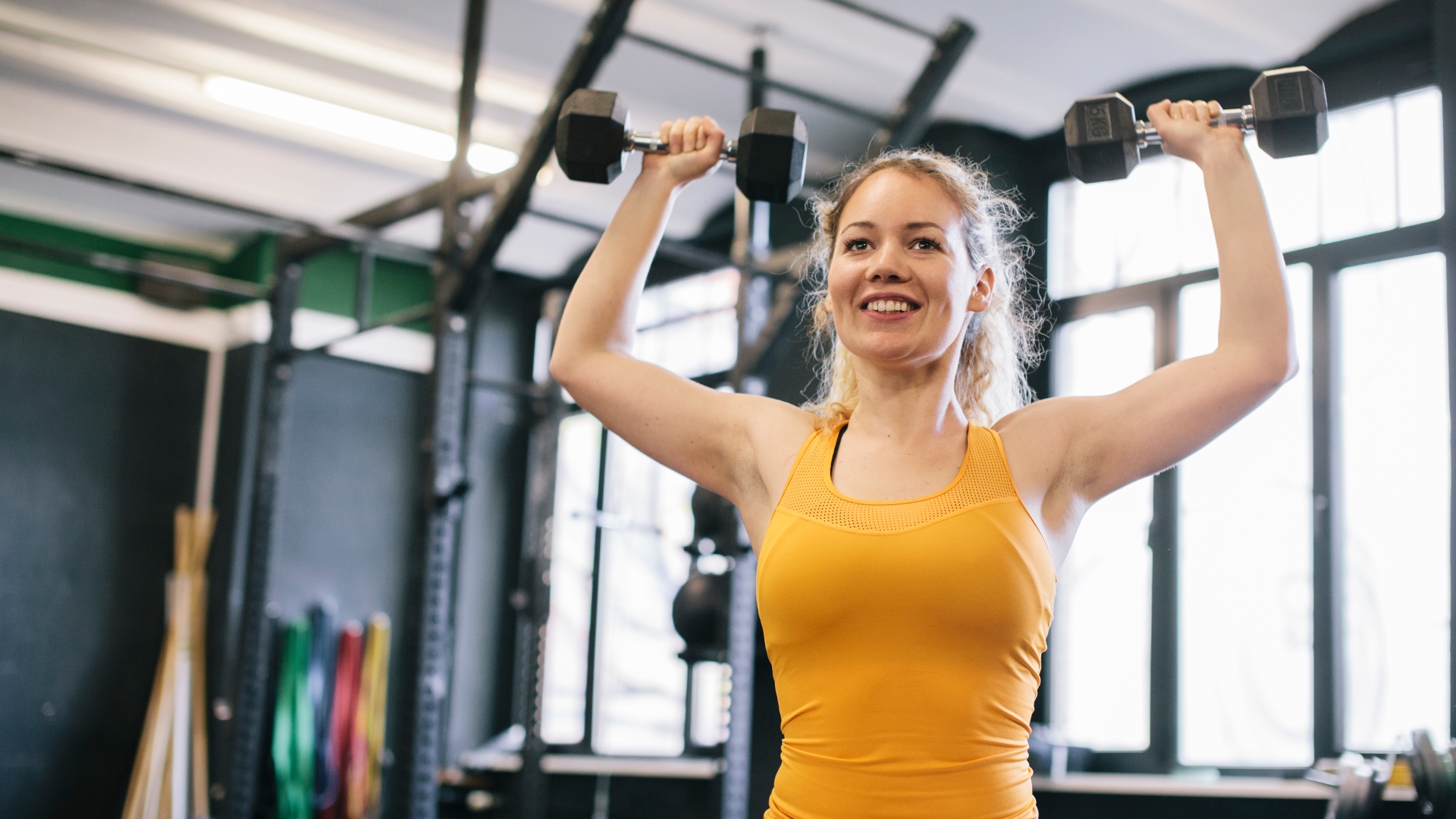 A woman doing dumbbell shoulder press