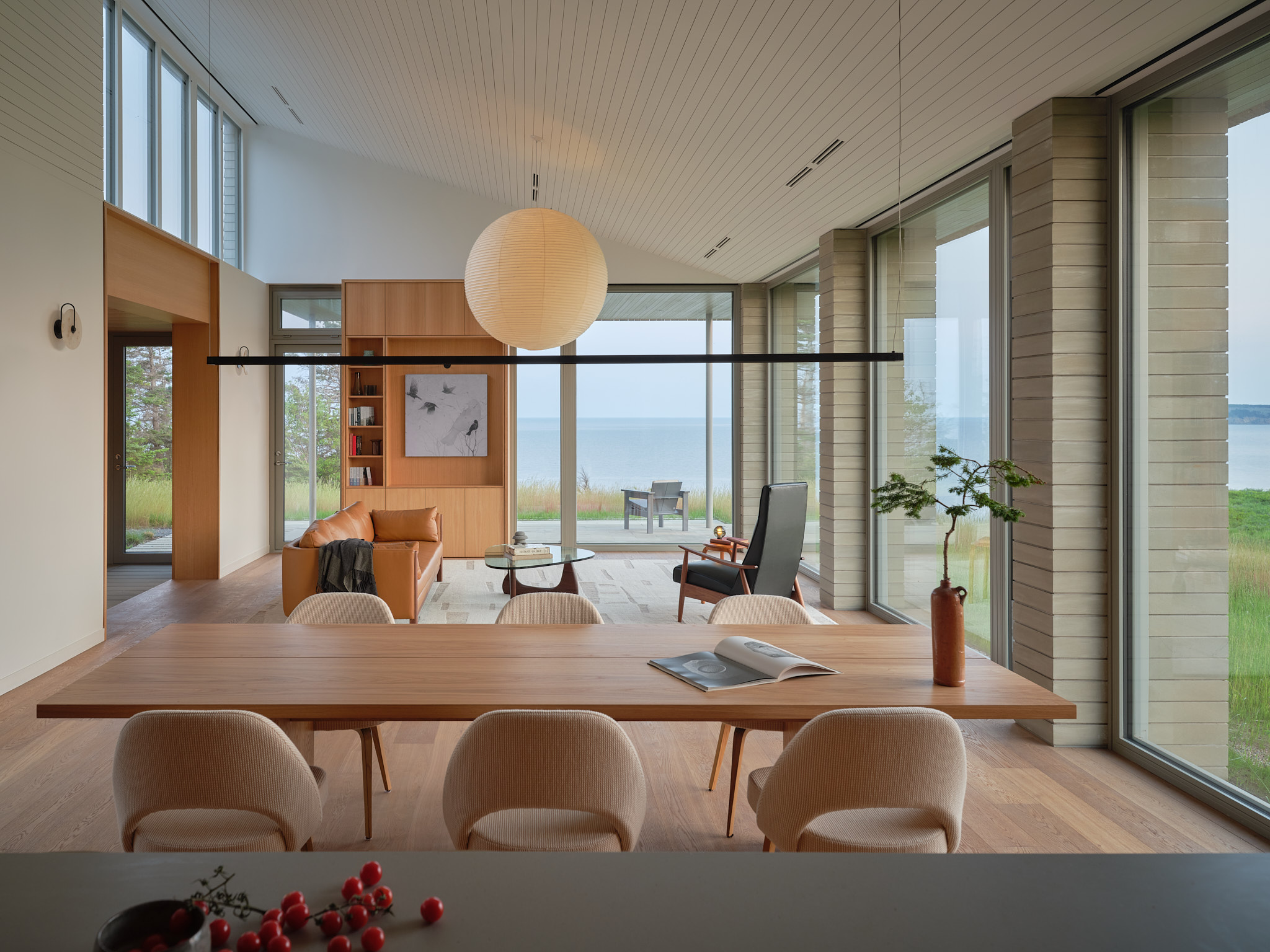 place of work's house in a meadow between the forest and the sea, an architectural, geometric house in leafy countryside