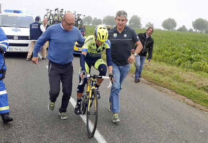 Bjarne Riis and a mechanic help Jesus Hernadez back on his bike