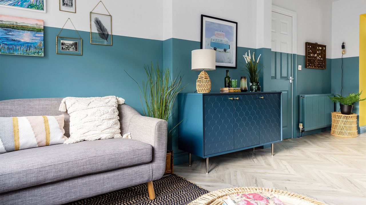 living room with blue and white half painted walls and sofa