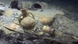 A photo of aged urns and vases sitting in sediment underwater