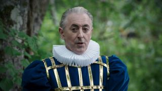 Alan Cumming talking while dressed in an extravagant outfit on The Traitors Season 3. 