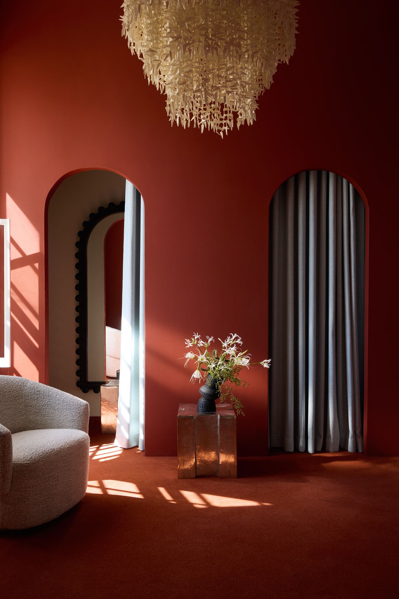 A series of shots capturing a young man dressed in patterned, or color-blocky, clothing, either standing in the sun-lit outdoor areas of a lush hotel, or inside a colorfully decorated suite filled with collectibles, artworks, and textural touches, or the interiors of that very space.