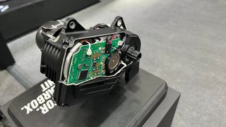 A cutaway e-bike motor on a stand at a trade show