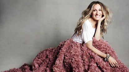 Sarah Jessica Parker smiling, wearing white t-shirt and rose pink ruffled skirt