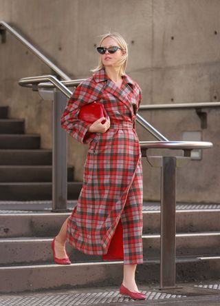 Violet Grace Atkinson wearing red check coat and ballet flats