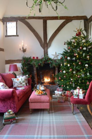 A living room in a Grade-II listed Tudor home with an open fireplace at Christmas