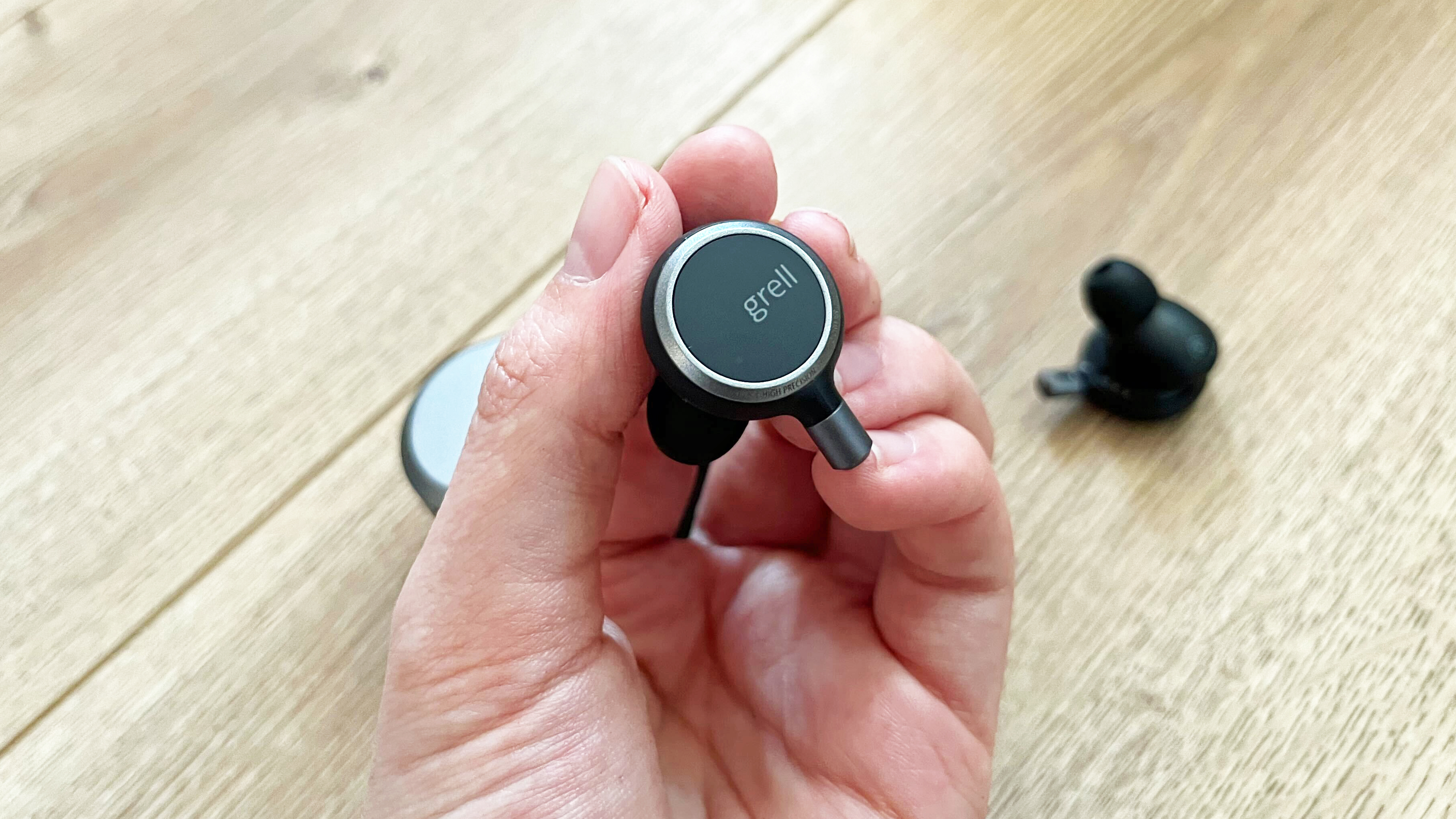 Grell Audio TWS/1 earbud in a hand