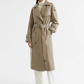 model wearing a reiss beige leather trench coat against a plain white background
