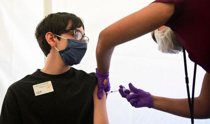 A teenager receives the COVID-19 vaccine.