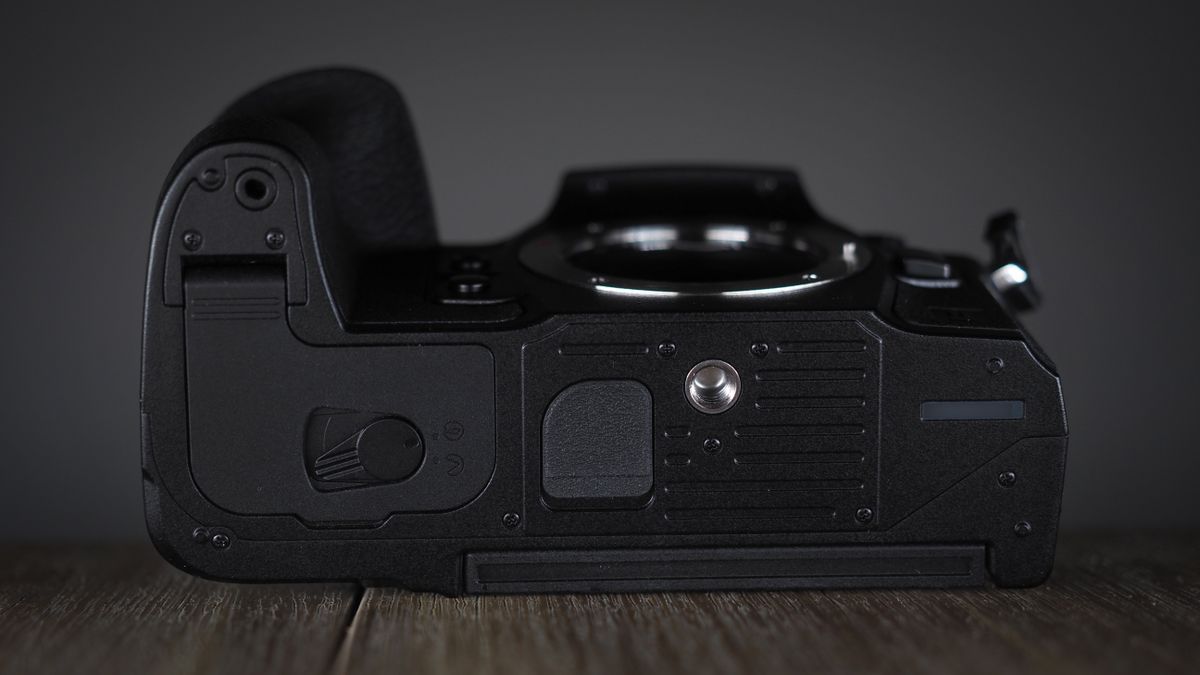 OM System OM-1 Mark II on a wooden surface, against a dark background