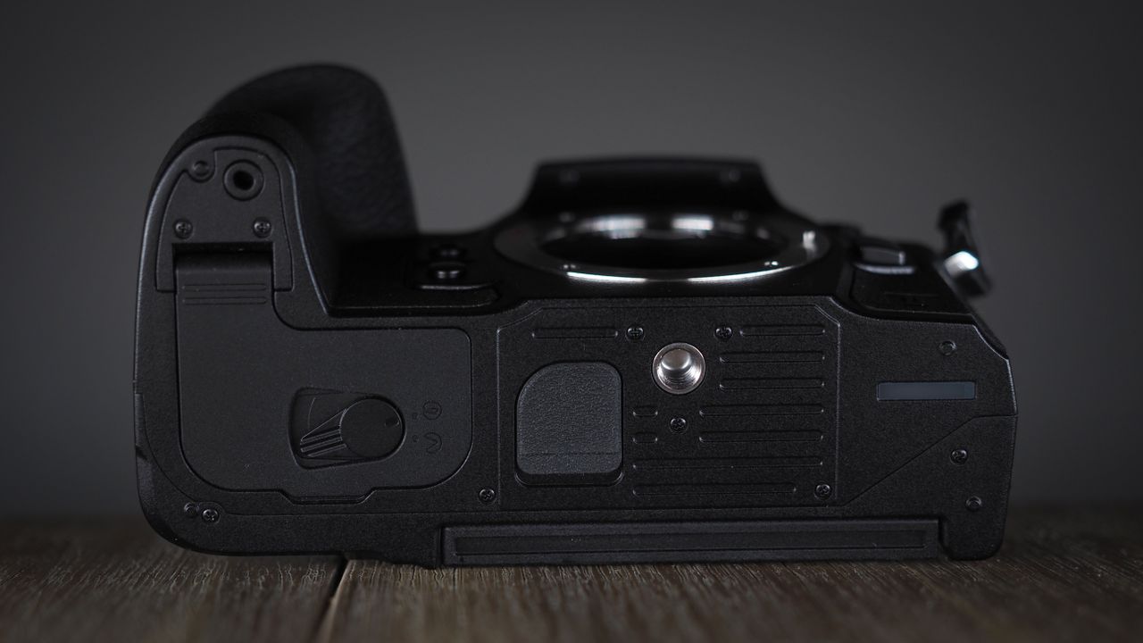 OM System OM-1 Mark II on a wooden surface, against a dark background