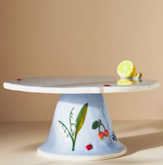 Cake stand decorated with lady birds, leaves, and half of a lemon.