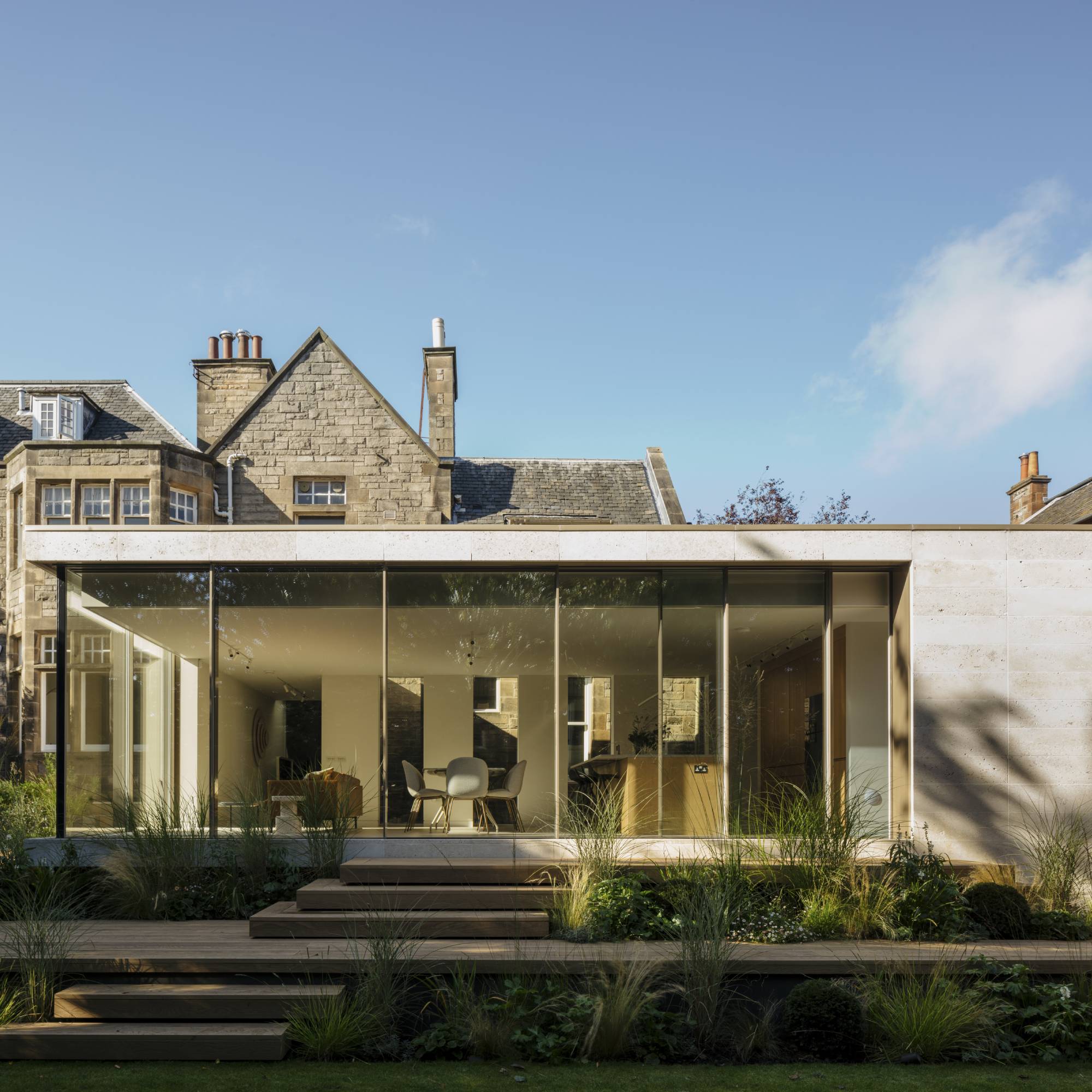 stone cladding on modern extension with bank of glass sliding doors