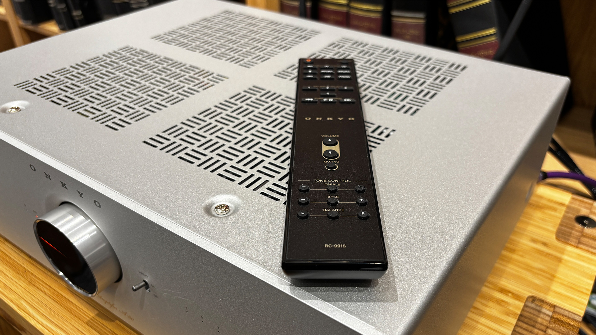 Onkyo Icon A-50 streaming amplifier on wooden hi-fi rack with remote control on top