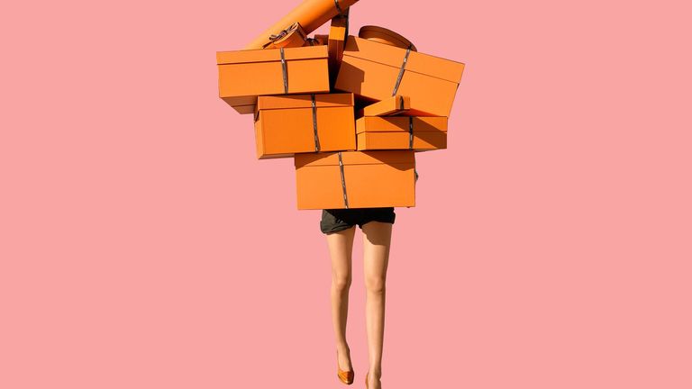 a person carrying many orange gift boxes
