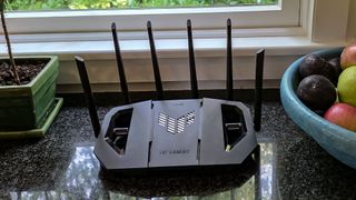 An Asus TUF Gaming BE6500 router on a windowsill.