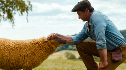 Hugh Jackman patting a sheep in The Sheep Detectives 