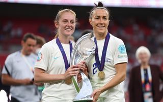 Keira Walsh and Lucy Bronze holding the European Championship trophy after beating Germany in the final