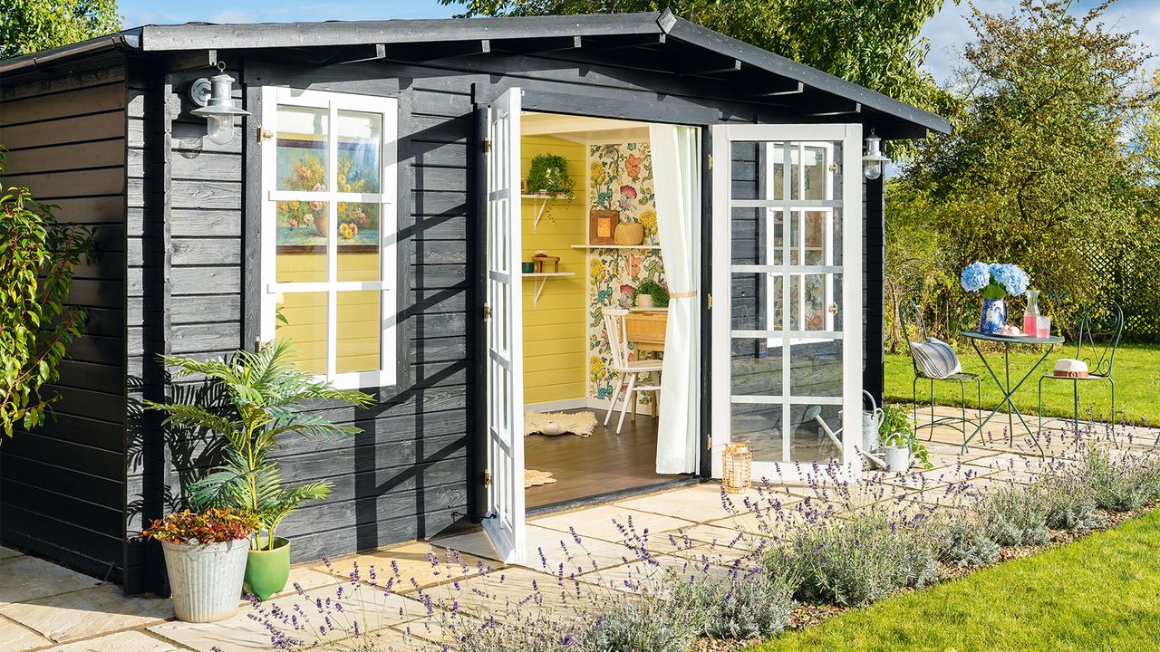 Black summerhouse with paved patio