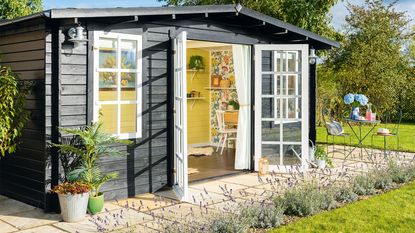 Black summerhouse with yellow paint