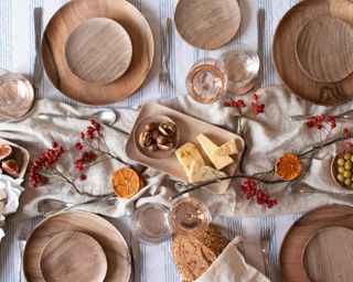 wooden plates on Christmas tablescape with floral decorations and cheese