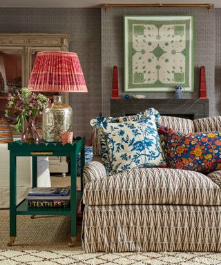 Sitting room with a sofa in a fabric by Sarah Vanrenen, framed antique wall fabric and table lamp with vintage sari lampshade