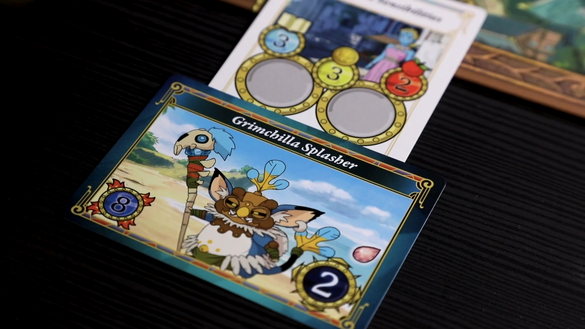 Ni No Kuni 2: The Board Game cards and components laid out on a dark surface