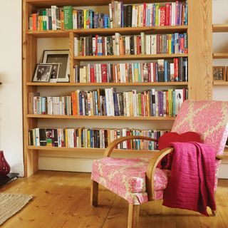 living room with wooden bookcase and books with armchair