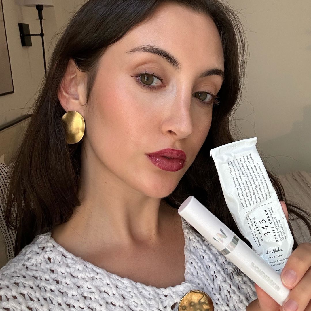 Alyssa Brascia taking a selfie holding two on-sale beauty products.