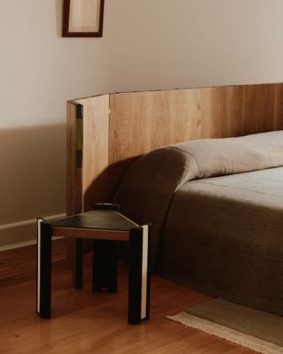 Curved wooden headboard with triangular side table